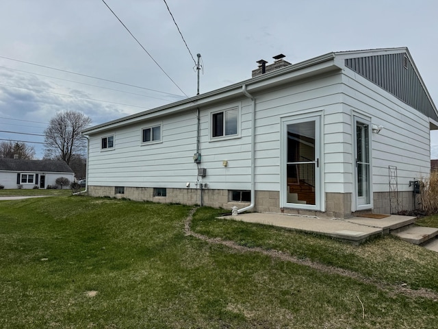 rear view of house with a yard and a chimney