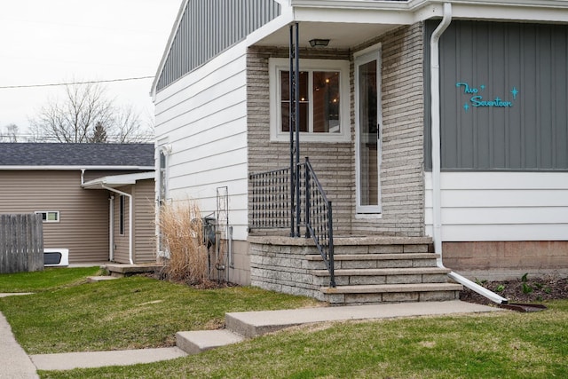 view of exterior entry featuring a lawn