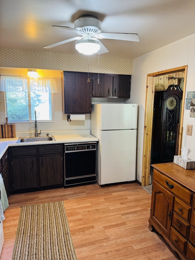 17745 Shubert Hwy, Alpena, MI 49707 - kitchen with freestanding refrigerator, black dishwasher, light wood-style floors, and light countertops
