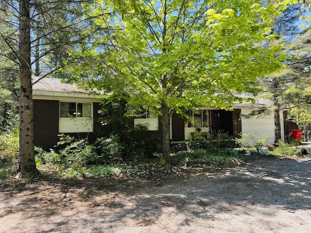 17745 Shubert Hwy, Alpena, MI 49707 - view of property hidden behind natural elements featuring brick siding and a garage