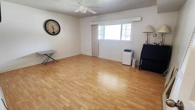 unfurnished room with baseboards, light wood-type flooring, and ceiling fan