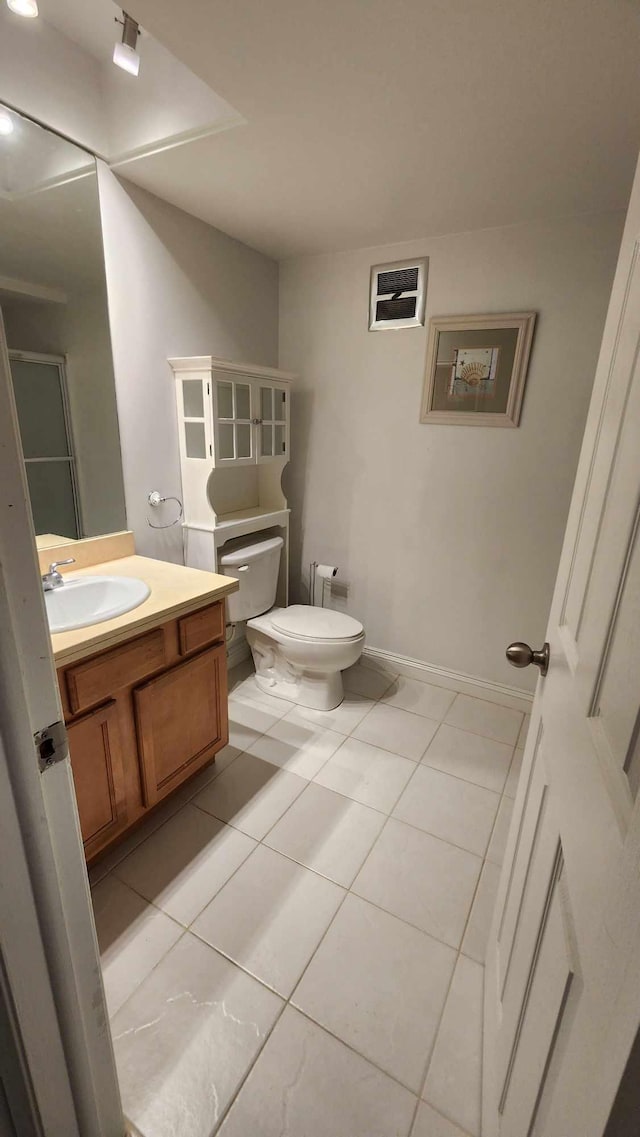 bathroom with tile patterned floors, vanity, toilet, and baseboards