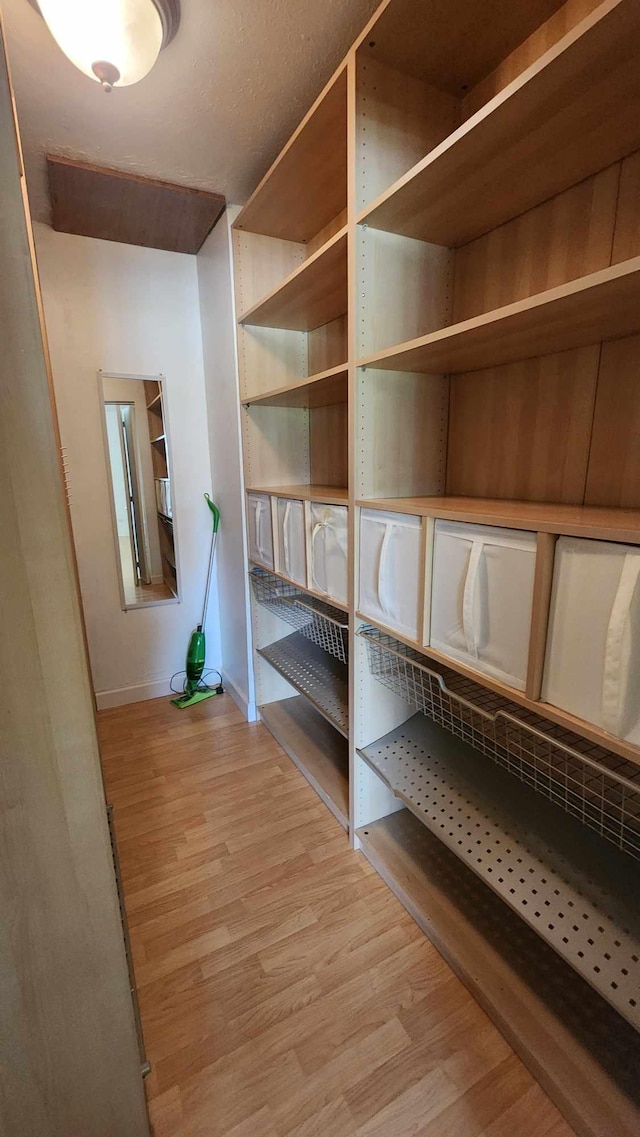 hall with baseboards and light wood finished floors