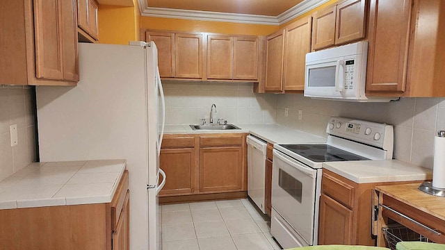 kitchen featuring white appliances, decorative backsplash, light tile patterned floors, a sink, and crown molding