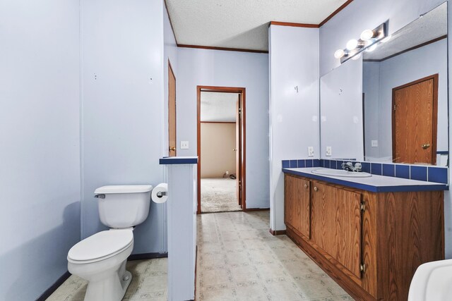 bathroom featuring crown molding, vanity, toilet, tile patterned floors, and a textured ceiling