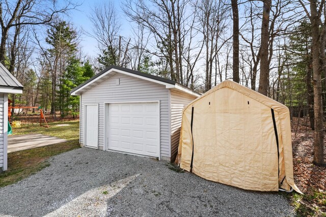 detached garage featuring gravel driveway