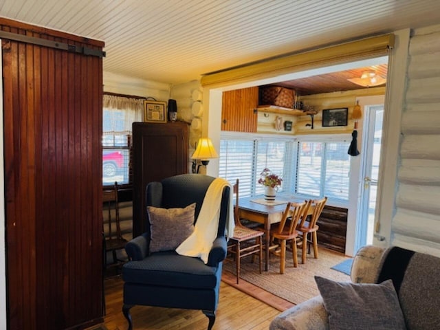 sitting room with wood finished floors and log walls