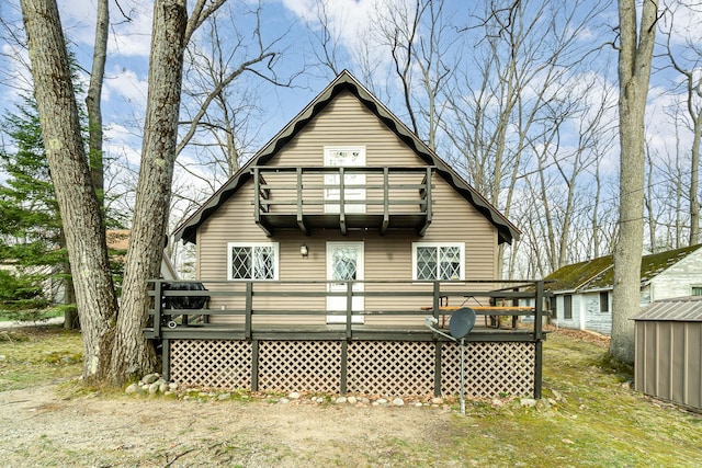 rear view of house featuring a deck and a balcony