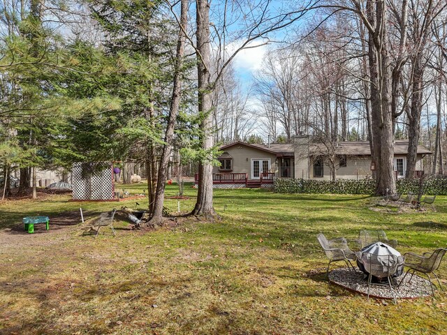 321 Greenleaf Dr, Houghton Lake, MI 48629 - view of yard with a fire pit and a deck