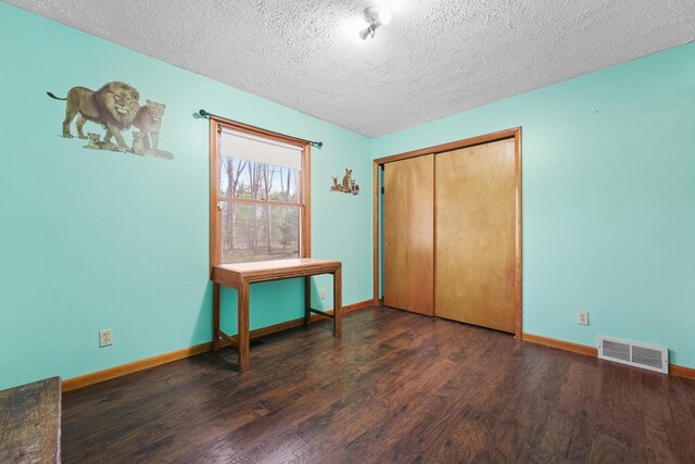 321 Greenleaf Dr, Houghton Lake, MI 48629 - unfurnished bedroom featuring baseboards, a textured ceiling, visible vents, and wood finished floors