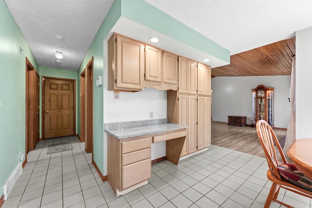 321 Greenleaf Dr, Houghton Lake, MI 48629 - kitchen with light countertops, a textured ceiling, built in desk, and light brown cabinetry