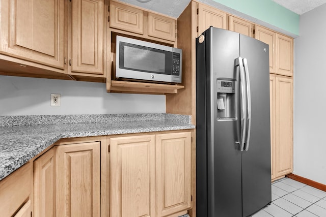 321 Greenleaf Dr, Houghton Lake, MI 48629 - kitchen featuring baseboards, appliances with stainless steel finishes, light tile patterned floors, and light brown cabinets