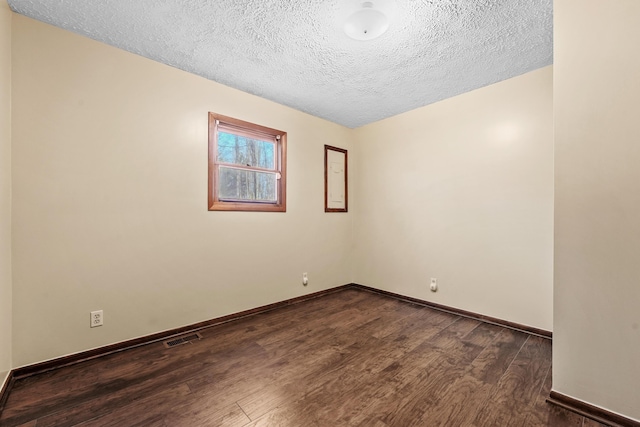 321 Greenleaf Dr, Houghton Lake, MI 48629 - empty room featuring baseboards, a textured ceiling, dark wood finished floors, and visible vents