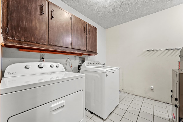 321 Greenleaf Dr, Houghton Lake, MI 48629 - clothes washing area with separate washer and dryer, a textured ceiling, cabinet space, and light tile patterned floors