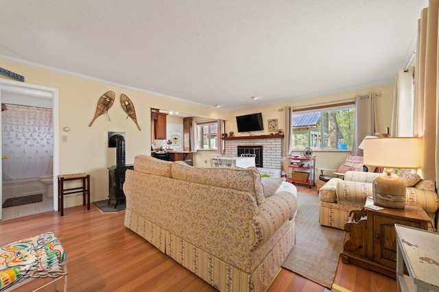 2931 Boulan Dr, Lewiston, MI 49756 - living area featuring light wood-style floors, crown molding, and a fireplace