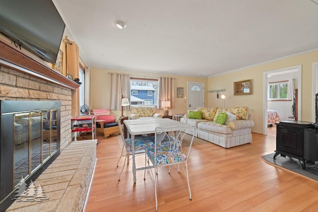 2931 Boulan Dr, Lewiston, MI 49756 - living room with light wood-style floors, ornamental molding, a fireplace, and a wood stove