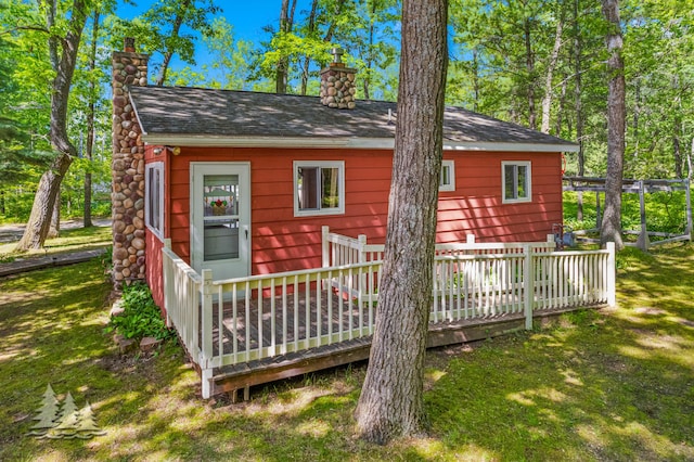2931 Boulan Dr, Lewiston, MI 49756 - back of property featuring a lawn, a chimney, and a wooden deck