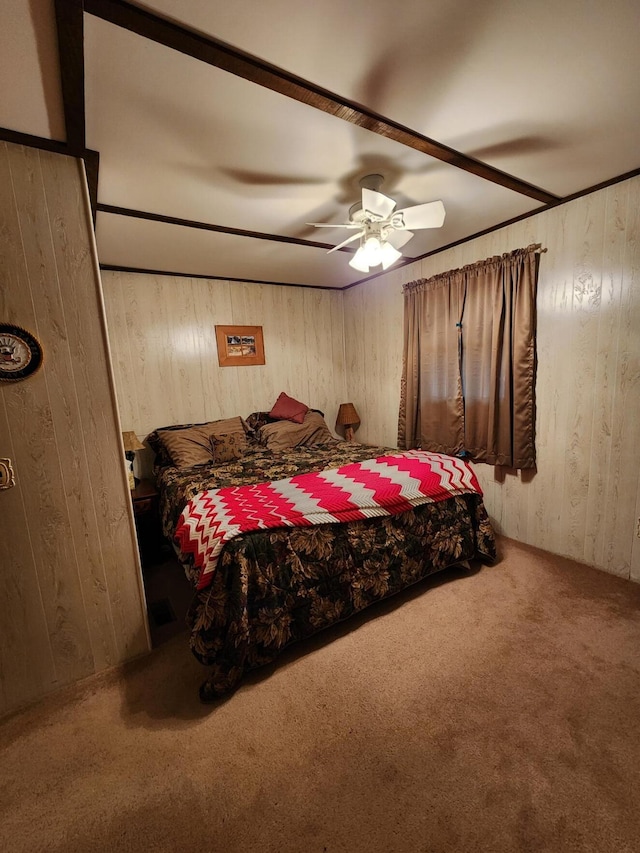 carpeted bedroom featuring wood walls and ceiling fan