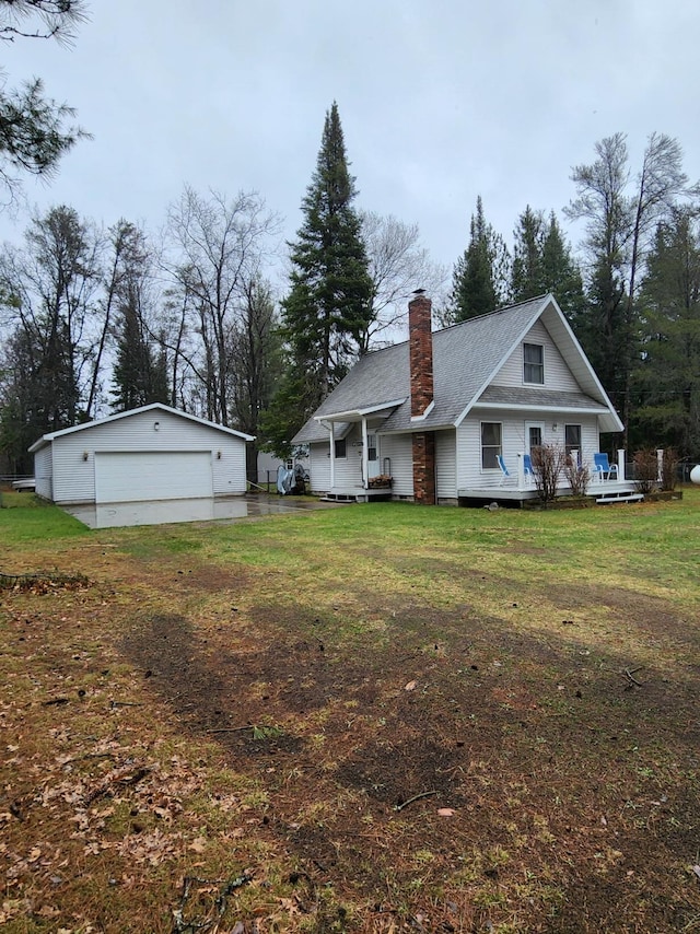 exterior space with a chimney, an outbuilding, a garage, and a lawn