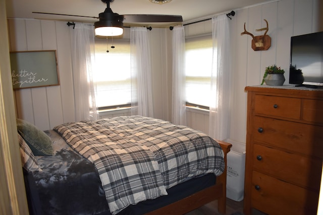 bedroom with a ceiling fan and a decorative wall