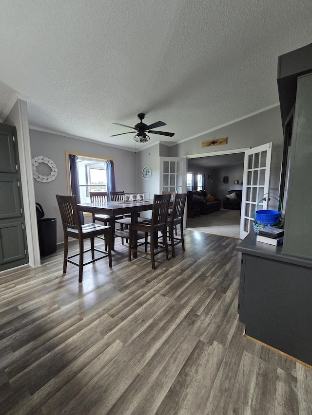 dining room featuring dark wood-type flooring, ceiling fan, crown molding, and a textured ceiling