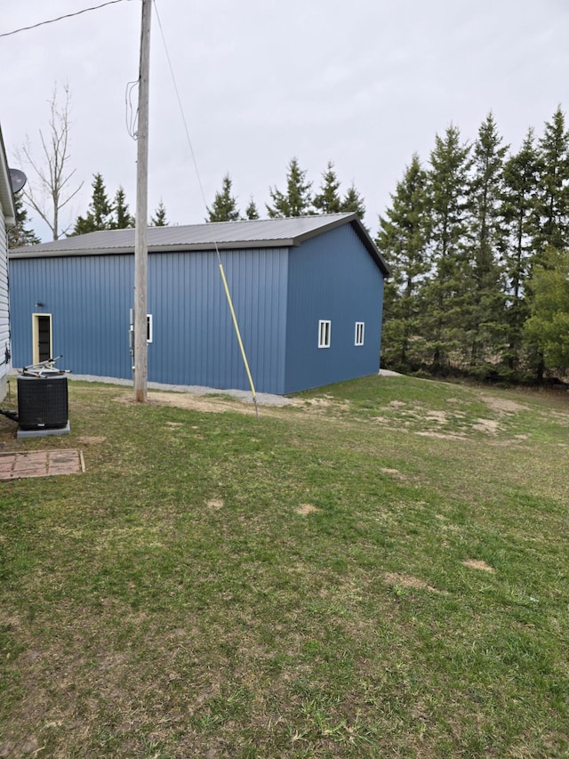 view of yard featuring an outdoor structure, a pole building, and central AC unit