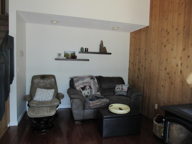 living area with wooden walls, baseboards, and wood finished floors