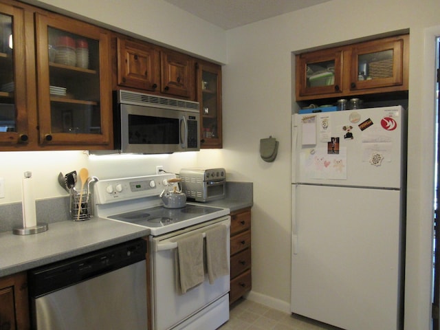kitchen featuring stainless steel appliances, glass insert cabinets, and a toaster