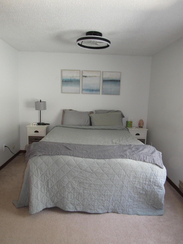 bedroom featuring baseboards, carpet flooring, and a textured ceiling