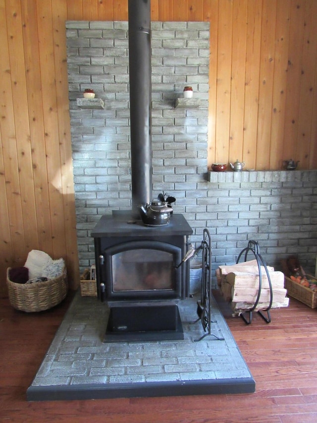 details featuring wooden walls, a wood stove, and wood finished floors