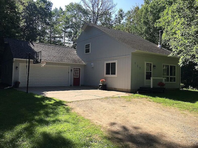 view of front facade with roof with shingles, an attached garage, driveway, and a front lawn