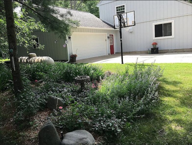 exterior space featuring a lawn, a garage, and a shingled roof