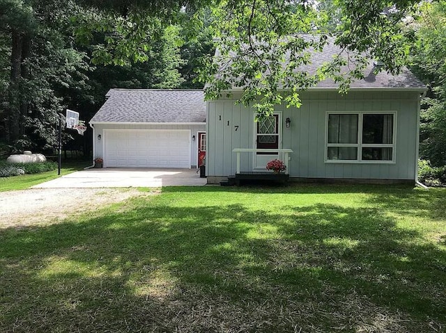 ranch-style home with roof with shingles, a front lawn, a garage, board and batten siding, and concrete driveway