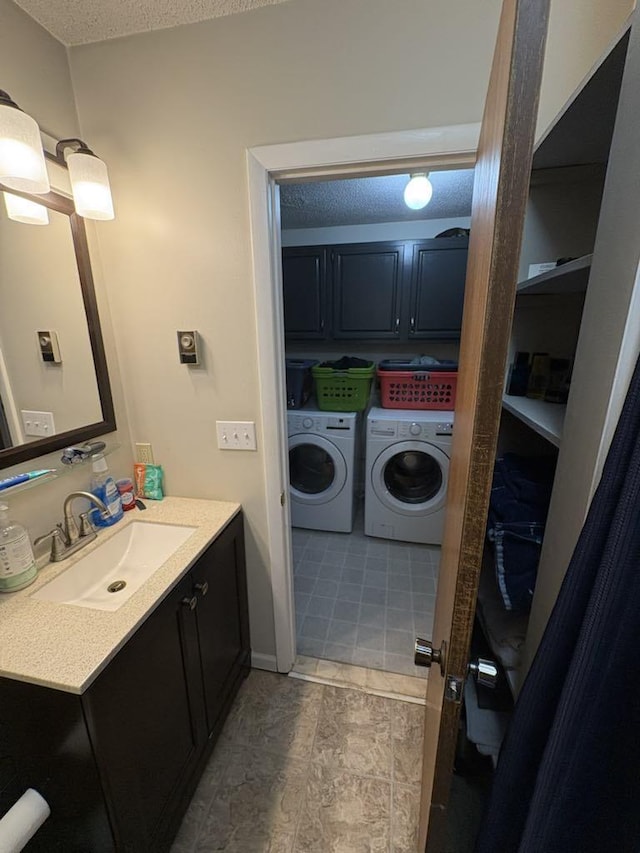 bathroom with vanity, a textured ceiling, and washer and clothes dryer