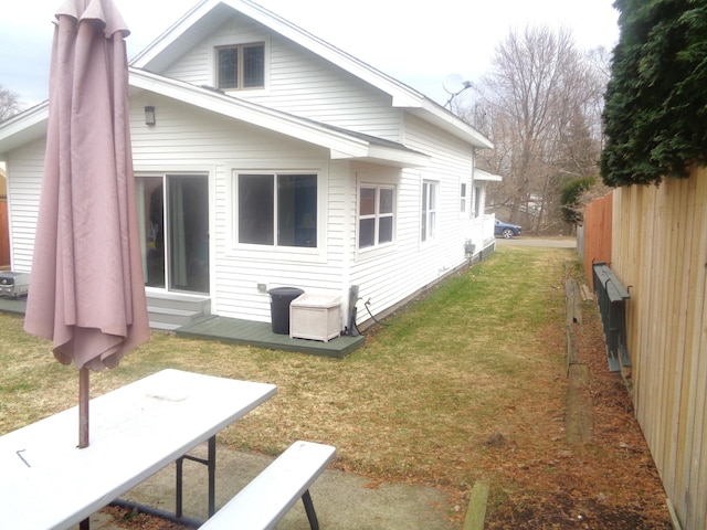 back of house with a lawn and fence