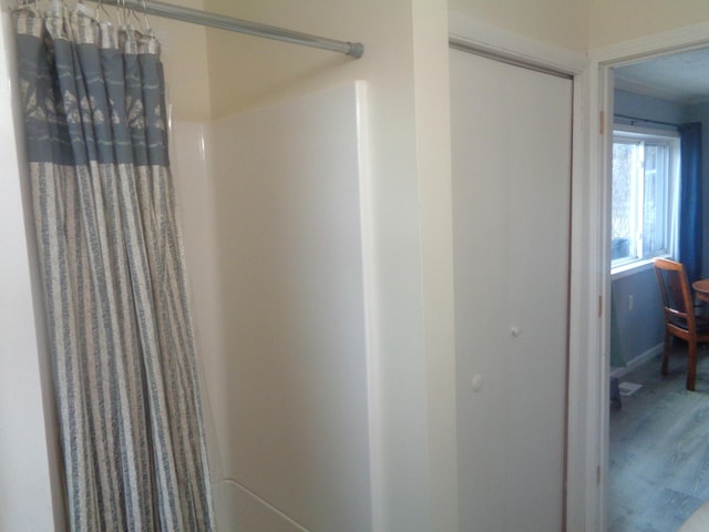 full bathroom featuring wood finished floors and curtained shower