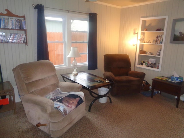 living area with wood walls, built in shelves, carpet, and crown molding