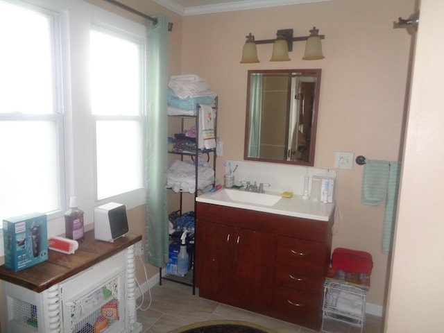 bathroom with baseboards, crown molding, and vanity
