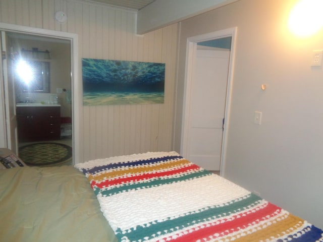 bedroom with wood walls and ensuite bathroom