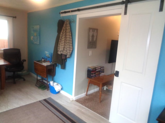 interior space with a barn door and baseboards