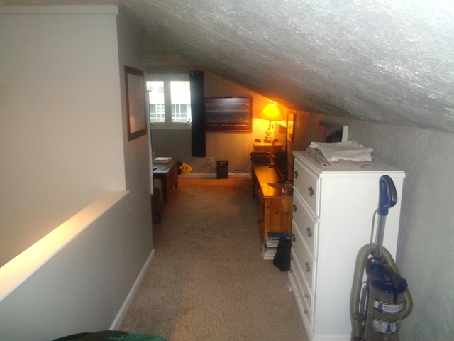 interior space featuring a textured ceiling, vaulted ceiling, and carpet