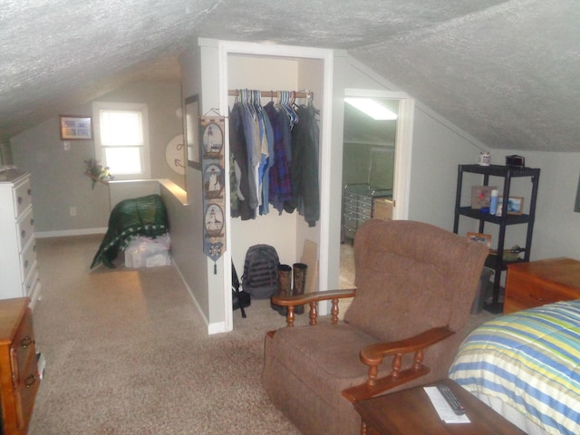 carpeted bedroom with a textured ceiling, a closet, lofted ceiling, and baseboards