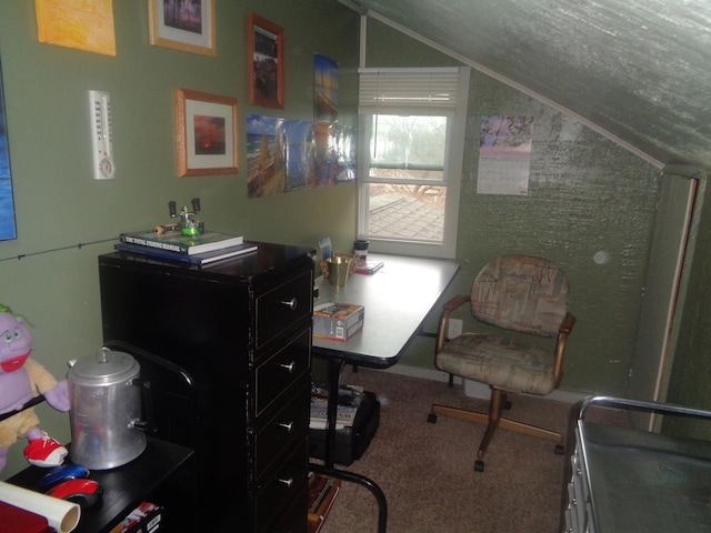 carpeted home office featuring vaulted ceiling