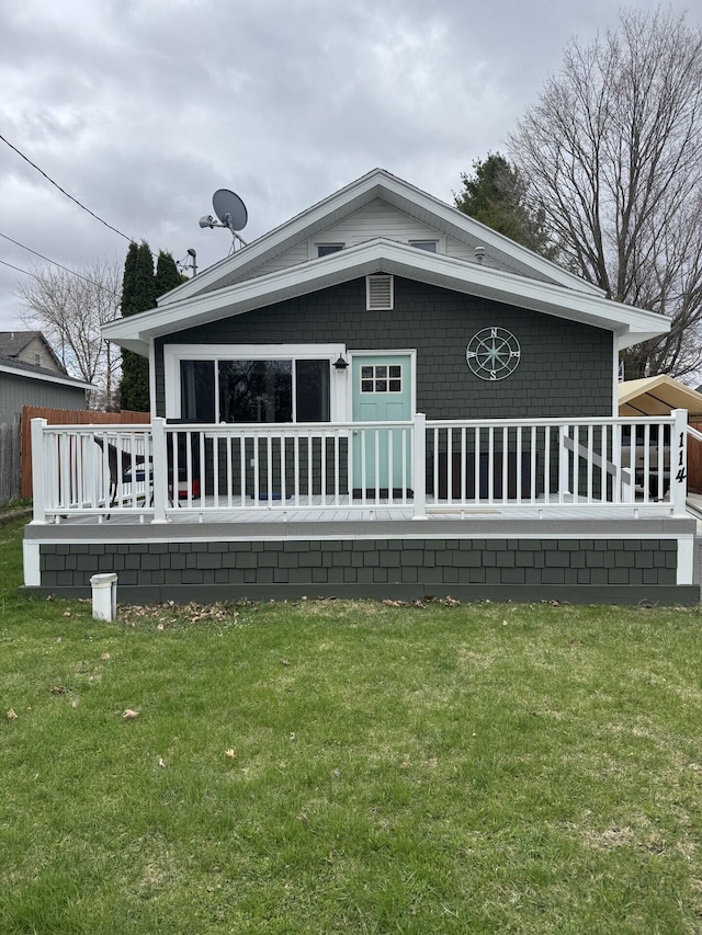 back of property with a deck and a yard
