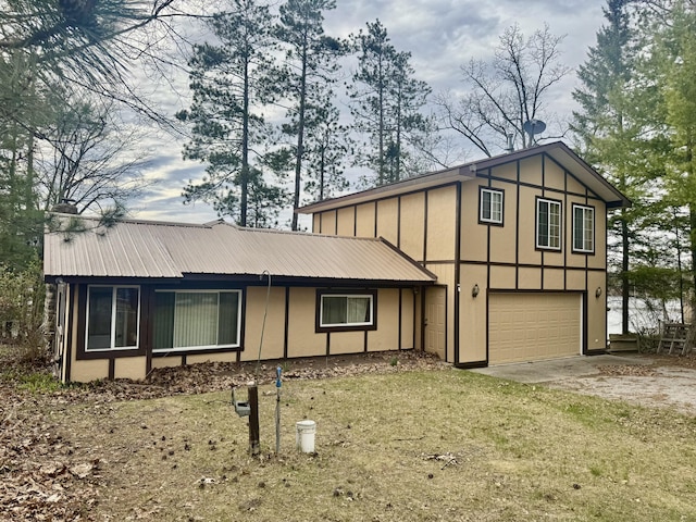 view of front of home with an attached garage, board and batten siding, driveway, and metal roof
