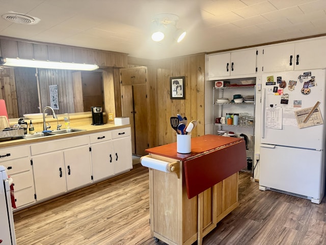 kitchen with freestanding refrigerator, visible vents, a sink, and light wood finished floors