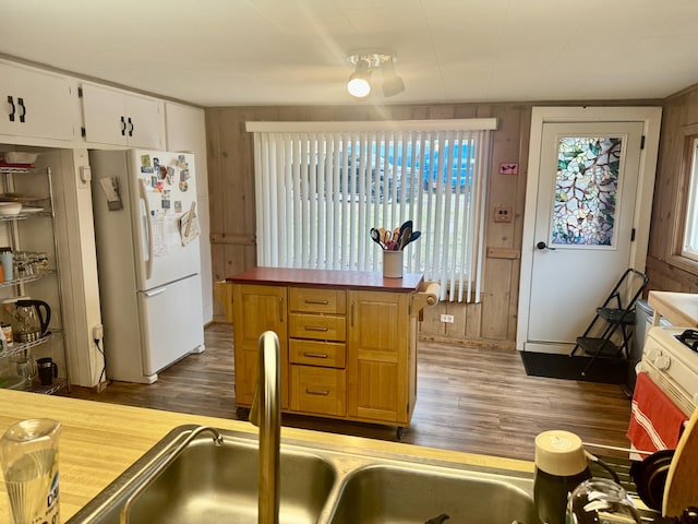 kitchen featuring freestanding refrigerator, a sink, dark wood-style floors, and white cabinets