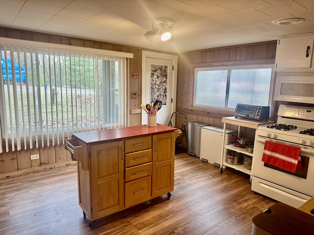 kitchen featuring wood counters, a kitchen island, hardwood / wood-style floors, and white appliances