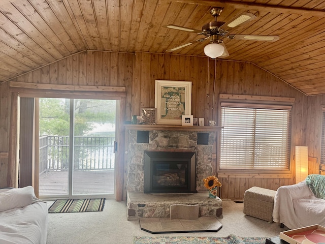 carpeted living area with wooden walls, vaulted ceiling, wooden ceiling, and plenty of natural light
