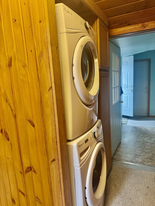laundry area with laundry area, stacked washer and clothes dryer, and wooden ceiling